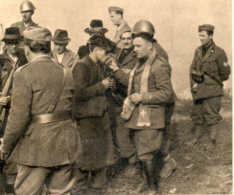 A Yugoslav partisan kisses the cross of a Black Shirts chaplain after last confession