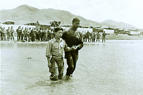 Korean soldier Lee Hyeong-hwan receives baptism with the guidance of U.S. Army officer Hubert Engram, near Seoul, around August 1952. The Institute for Military History said, “Looking at Lee’s clothes, he must have been a civilian attached to the U.S. 8th Army, or an interpreter.”
